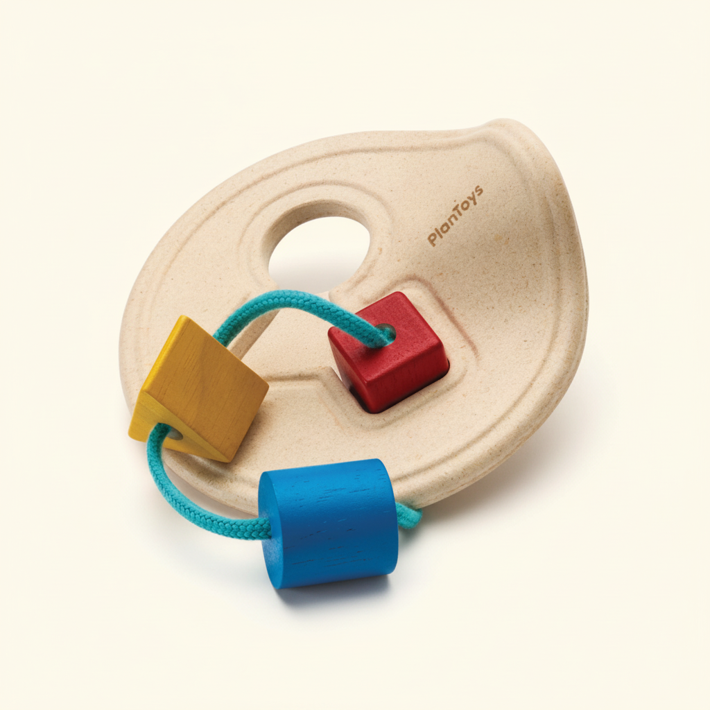 PlanToys wooden shape sorter box with its shape pieces on a plain cream background